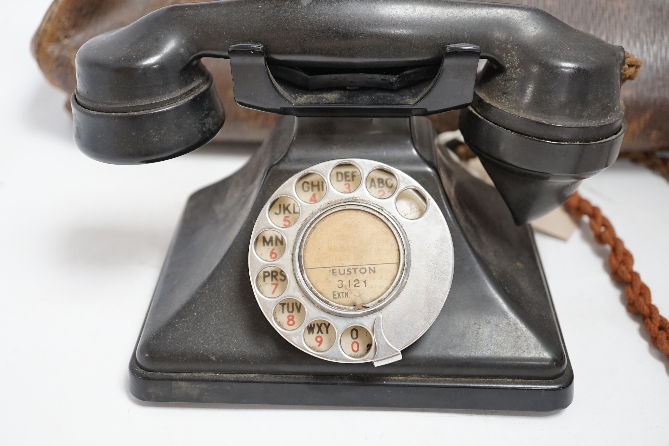 A brown leather Gladstone bag with a G.P.O. stamp and a pyramid-shaped black Bakelite telephone stamped G.P.O. Condition - poor